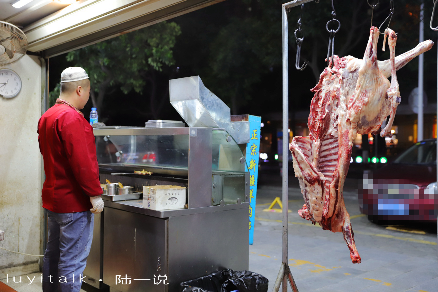 门口挂着一只羊,师傅正在那边削肉剔骨.