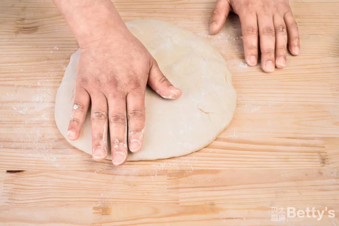 10/用手拍打面团,将多余气体排出.11/将一半面团往中心折叠.