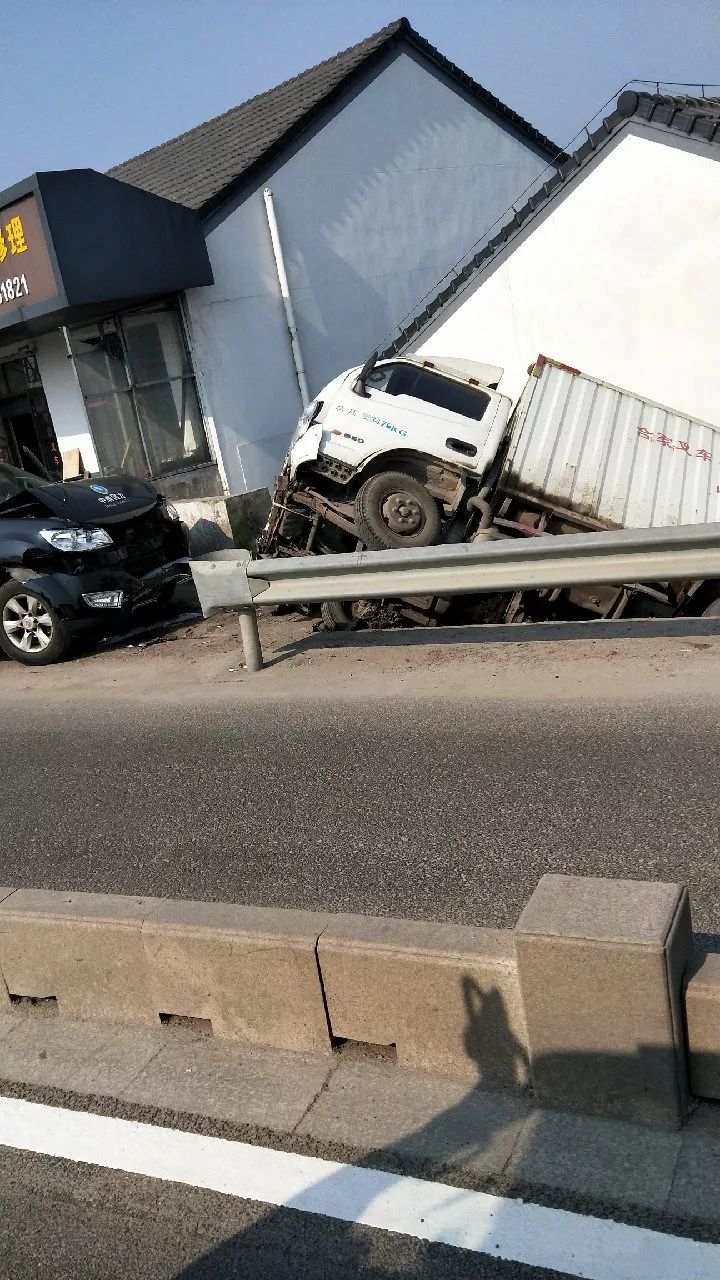 谢塘一厢式货车撞车后直接飞上人家屋顶!