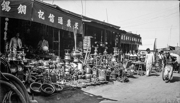 1937年的北京一群拉车苦力在城门里等活一个老头在城门外卖梨