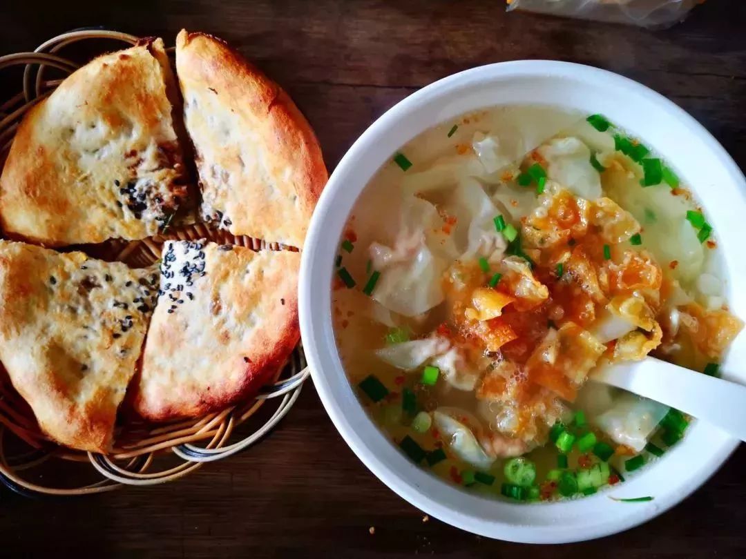 馄饨跟烧饼就端到了我们跟前,看着刚出炉冒着热气的缙云烧饼忍不住