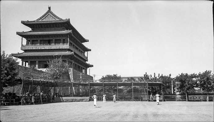 1937年的北京一群拉车苦力在城门里等活一个老头在城门外卖梨