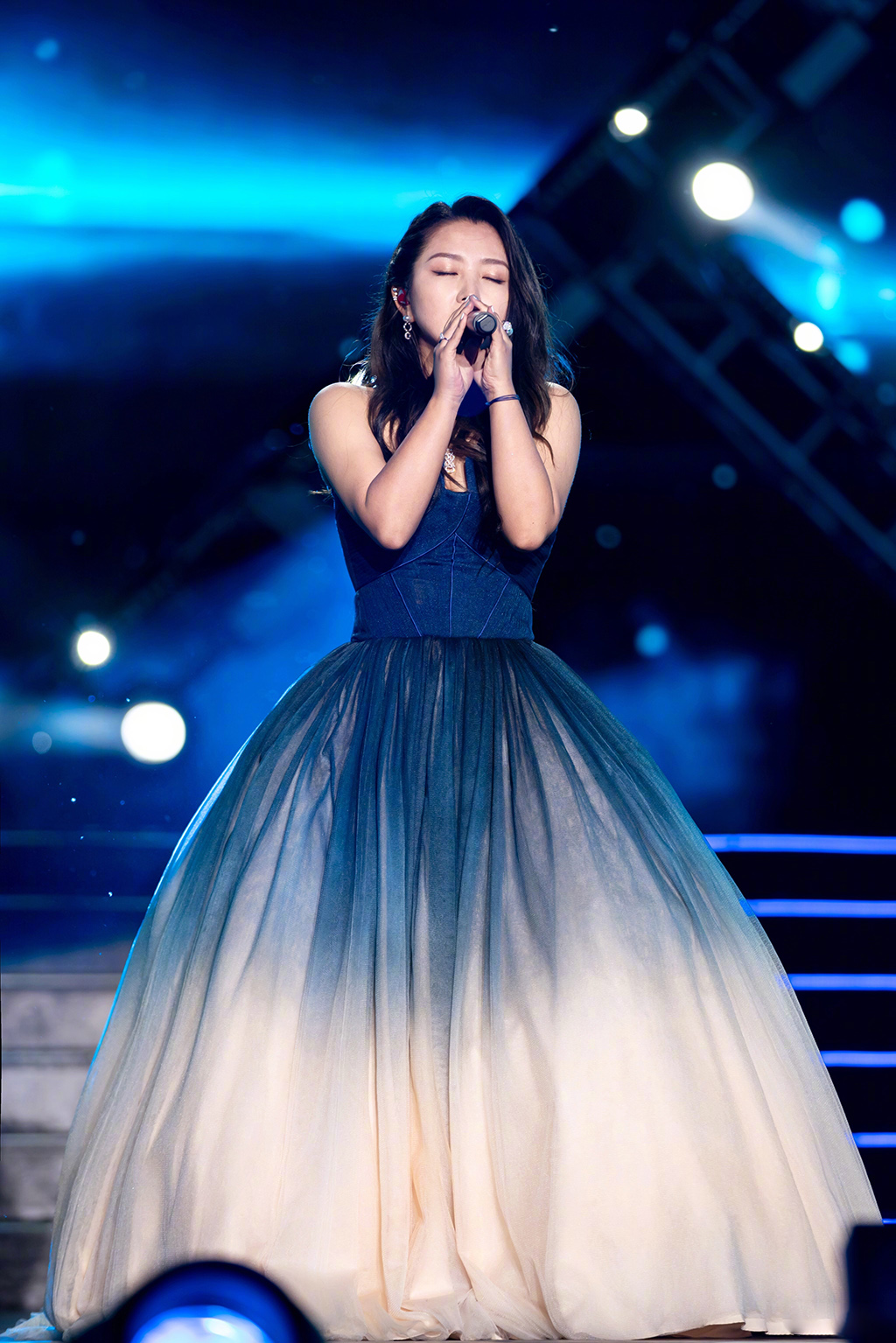 何洁身穿的是渐变色抹胸大礼服裙,这类型的款式也比较常见,像女明星