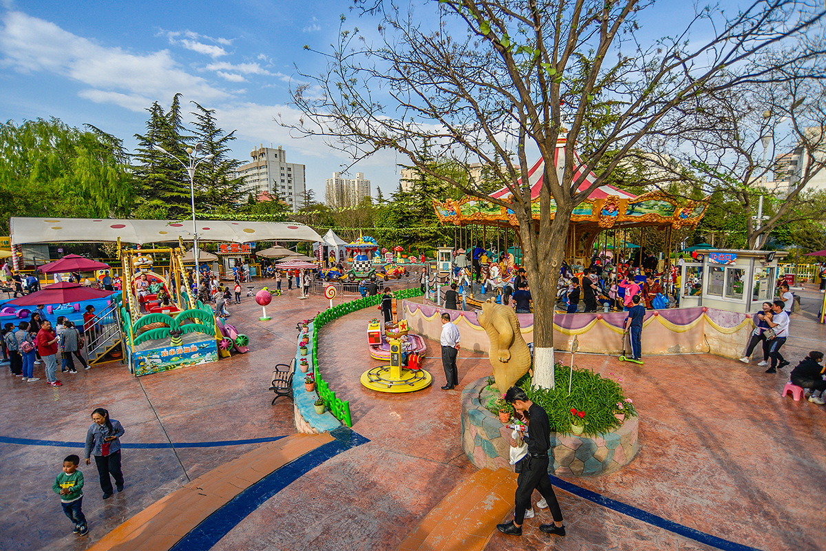在公园的儿童游乐场,这里由几块规划功能合理的游乐区组成,电动器械