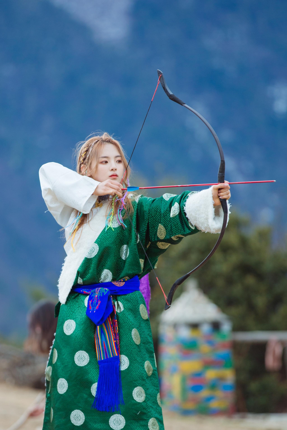 杨超越彩辫新造型亮相穿绿色藏服射箭英气十足