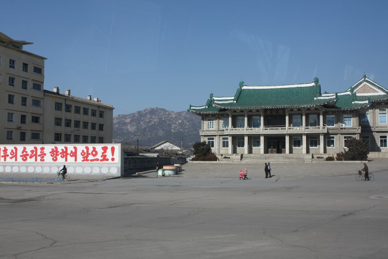 圖為朝鮮開城街頭的古老建築,一名朝鮮小男孩在路上張望.