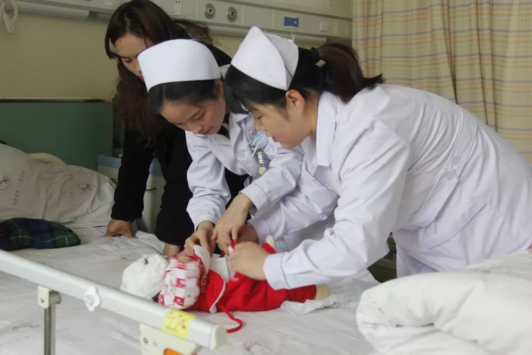 柯和几名护士充当起了临时妈妈大家轮流照看她喂奶,换衣服,换尿布喂奶