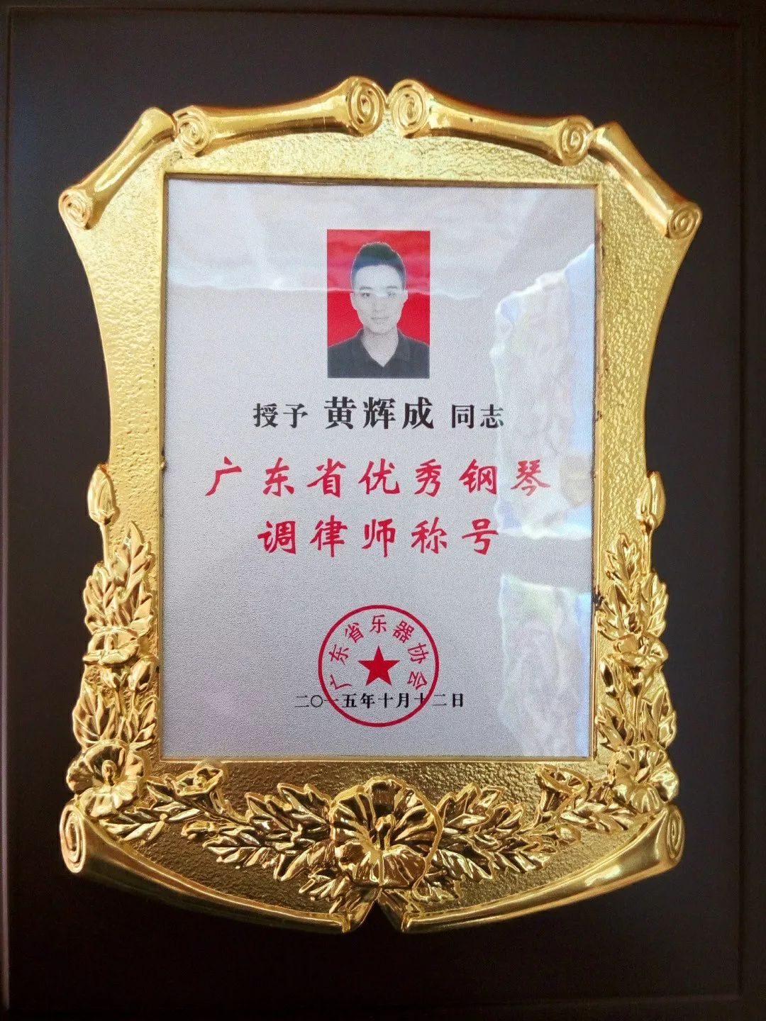 图为黄辉成获得"广东省优秀调律师"荣誉称号的奖牌.
