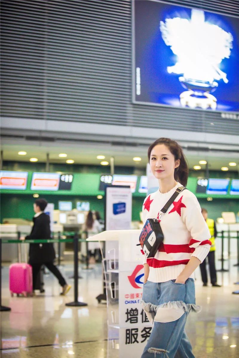 张雯机场随拍 造型简约破洞牛仔裤抢镜