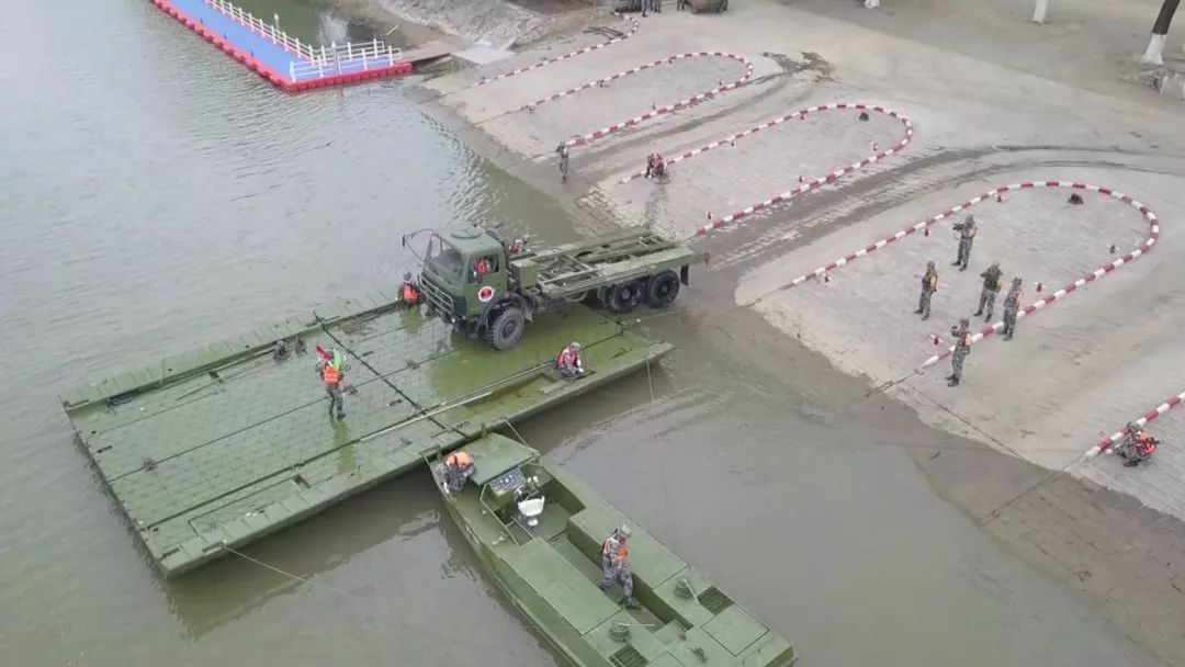 操作手使用旗语指挥汽艇渡送门桥参赛队员迅速完成门桥架设和车辆装载