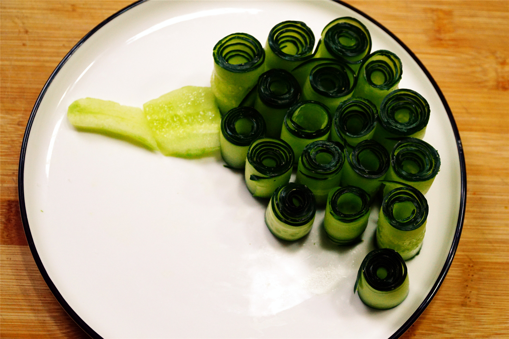 第四步:孔雀的眼睛要用一点黄瓜丝做成,头翎用樱桃的梗,配上辣椒仔就