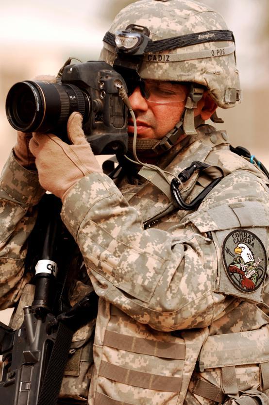 我们可以看他左臂富有特色圆形臂章,上面刺有一只穿着四色丛林迷彩的