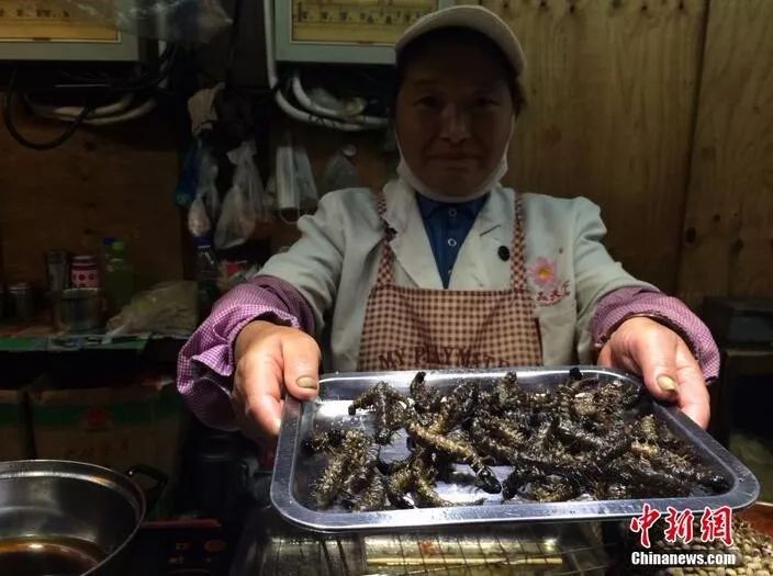 图为一位云南大妈向你推荐油炸水蜈蚣. 缪超 摄