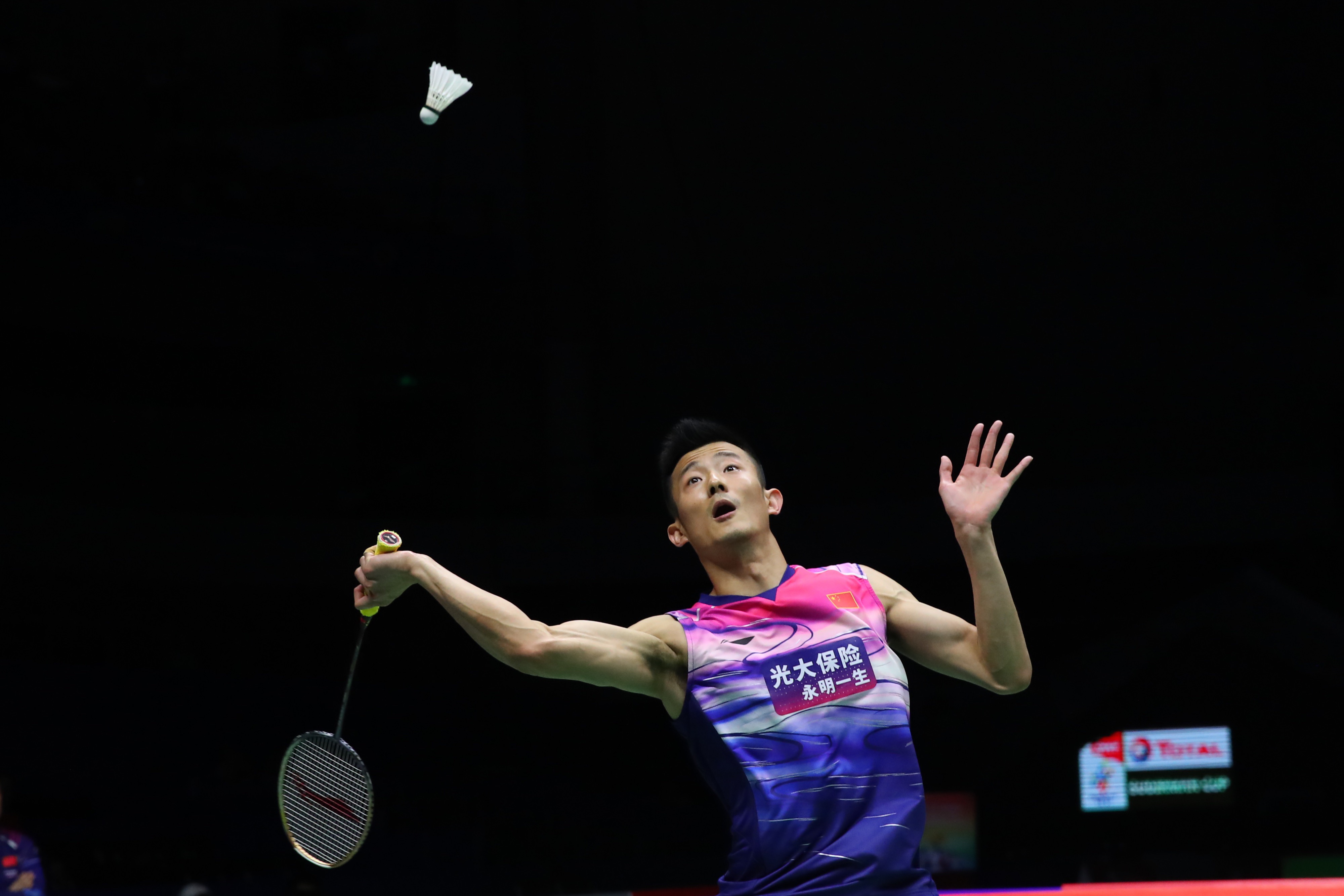 中国队选手谌龙在男子单打比赛中回球.