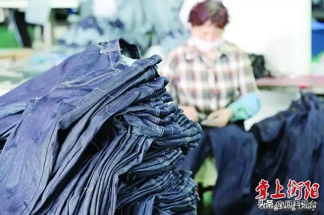 在这个临时厂房里,工人正在为牛仔裤生产线下料