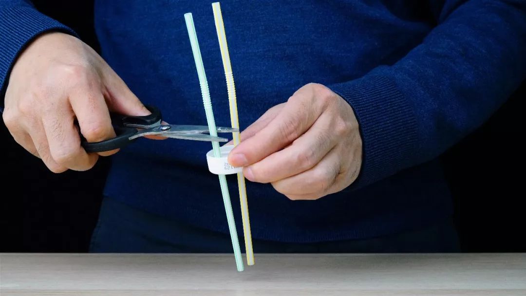 2.将吸管分别插入两个小孔,将其中一根减掉一半.