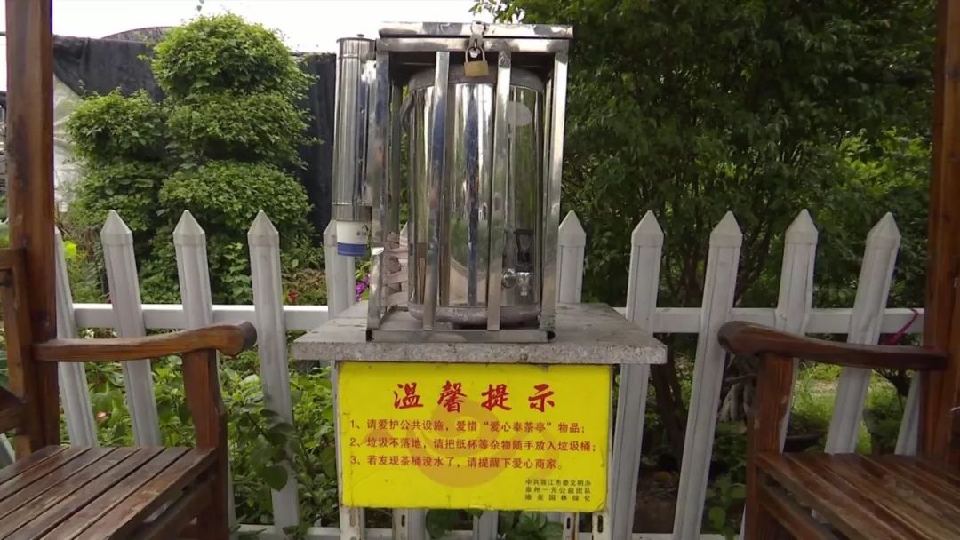 "随后,陈元礼走进一家花艺场,提着烧好的水,往奉茶亭的茶桶里倒水.