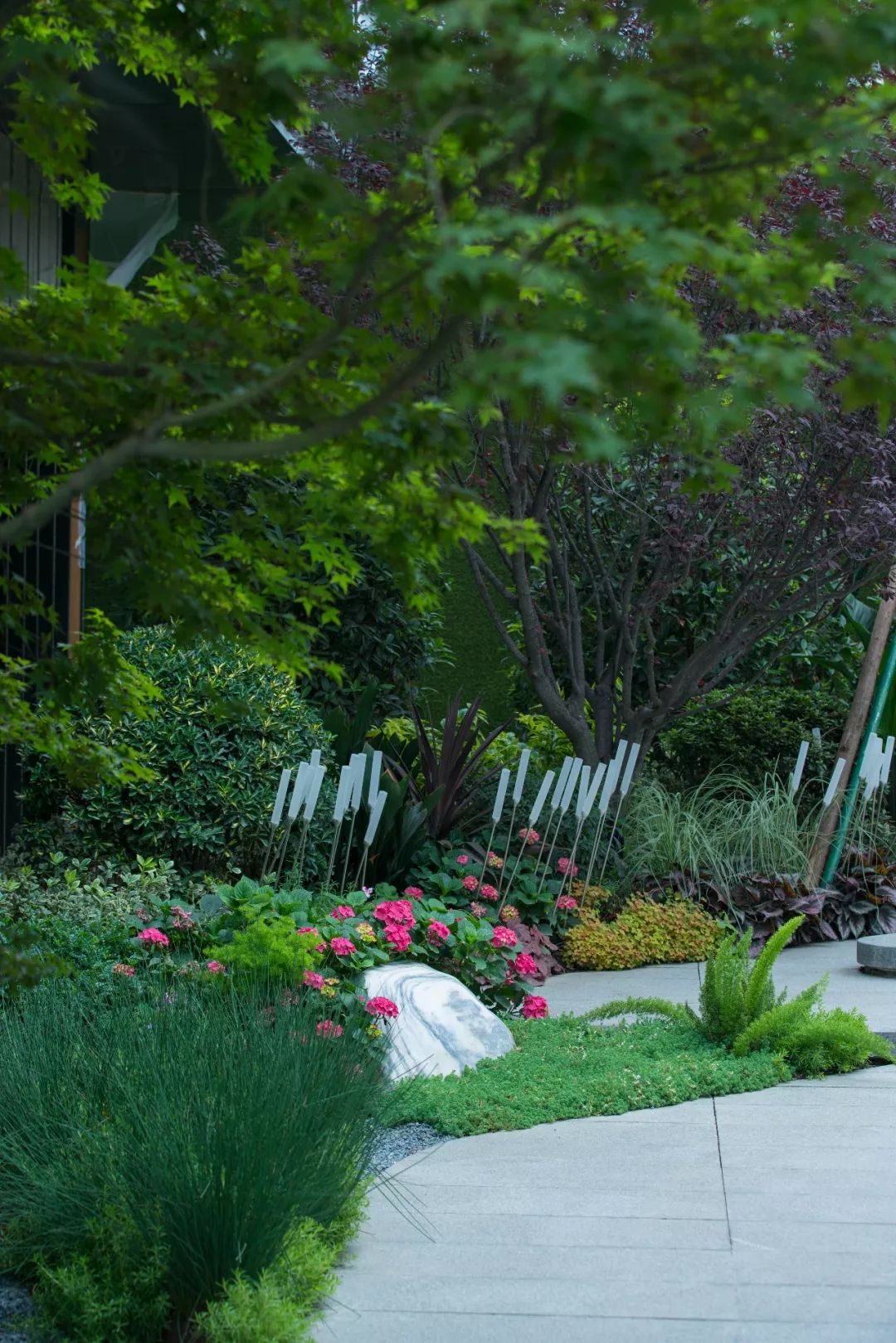 与后场般热闹的环境氛围相得益彰景墙两侧搭配花境,整体质感更为饱和