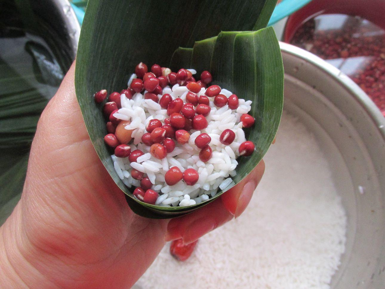 4,放上红豆和糯米,中间放红枣,至8分满就可以,包三角粽米不可以放的太