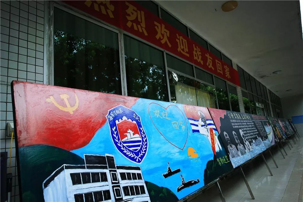 板报"欢迎回家"的欢迎横幅鲜红醒目这个他们荣耀一生的地方这个他们