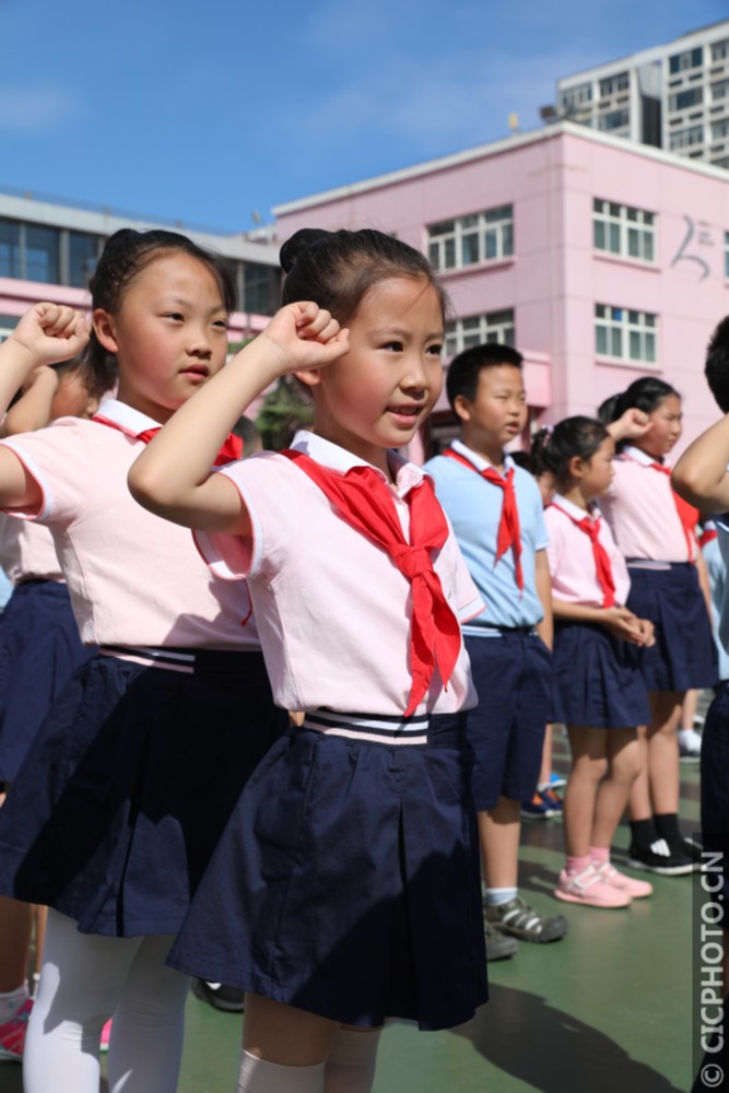 5月31日,北京市中关村第三小学,高年级的同学们为新入队的同学们戴