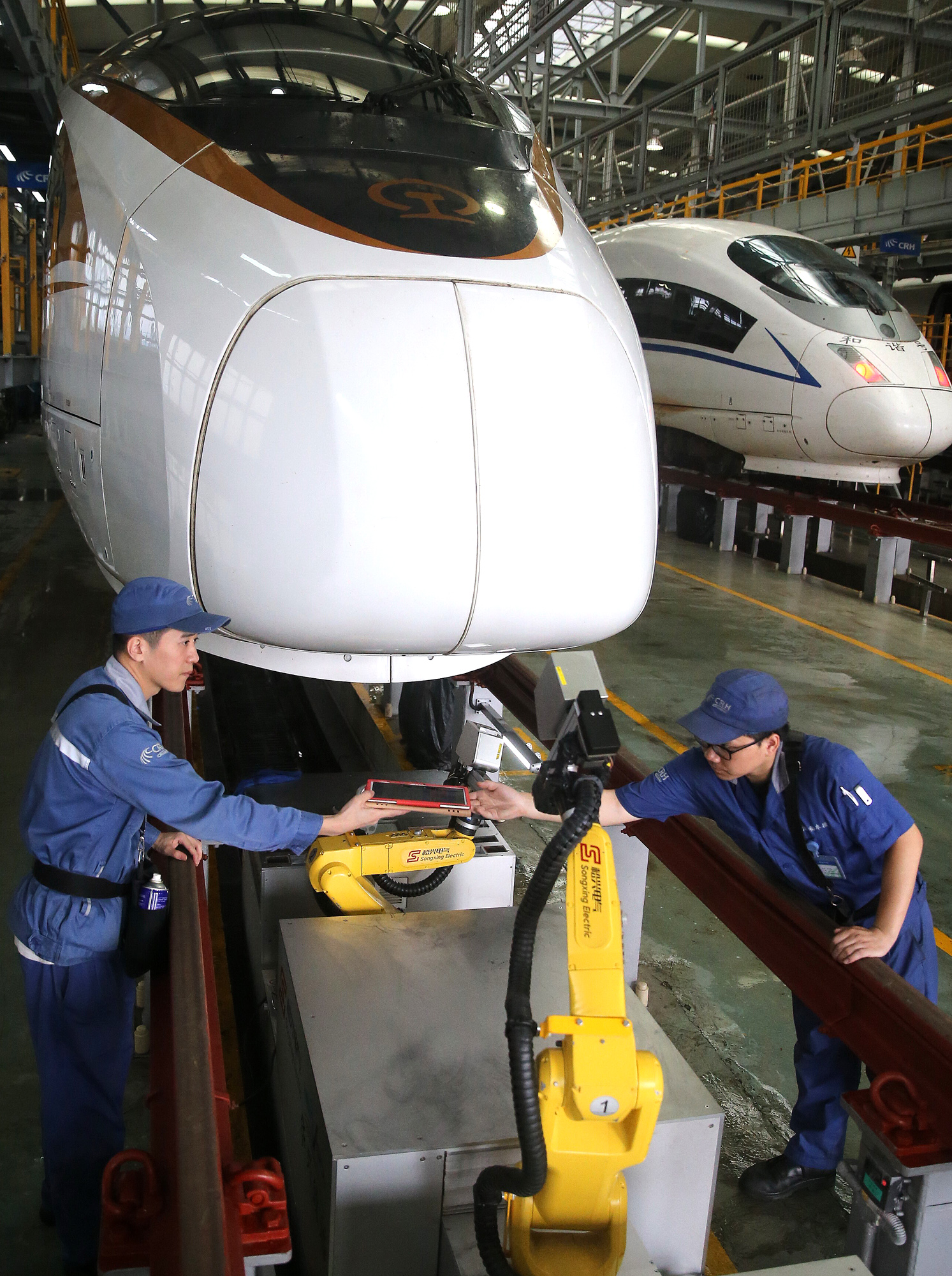 5月31日,动车组机械师操作机器人对复兴号高铁列车进行一级检修作业