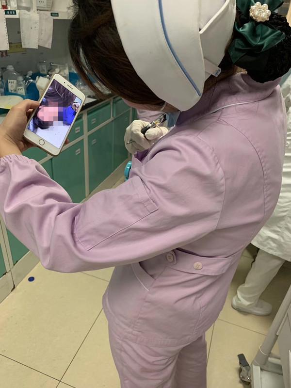 镜头里身着制服的女护士一手拿着笔,似乎刚从工作中抽身出来,手套还未