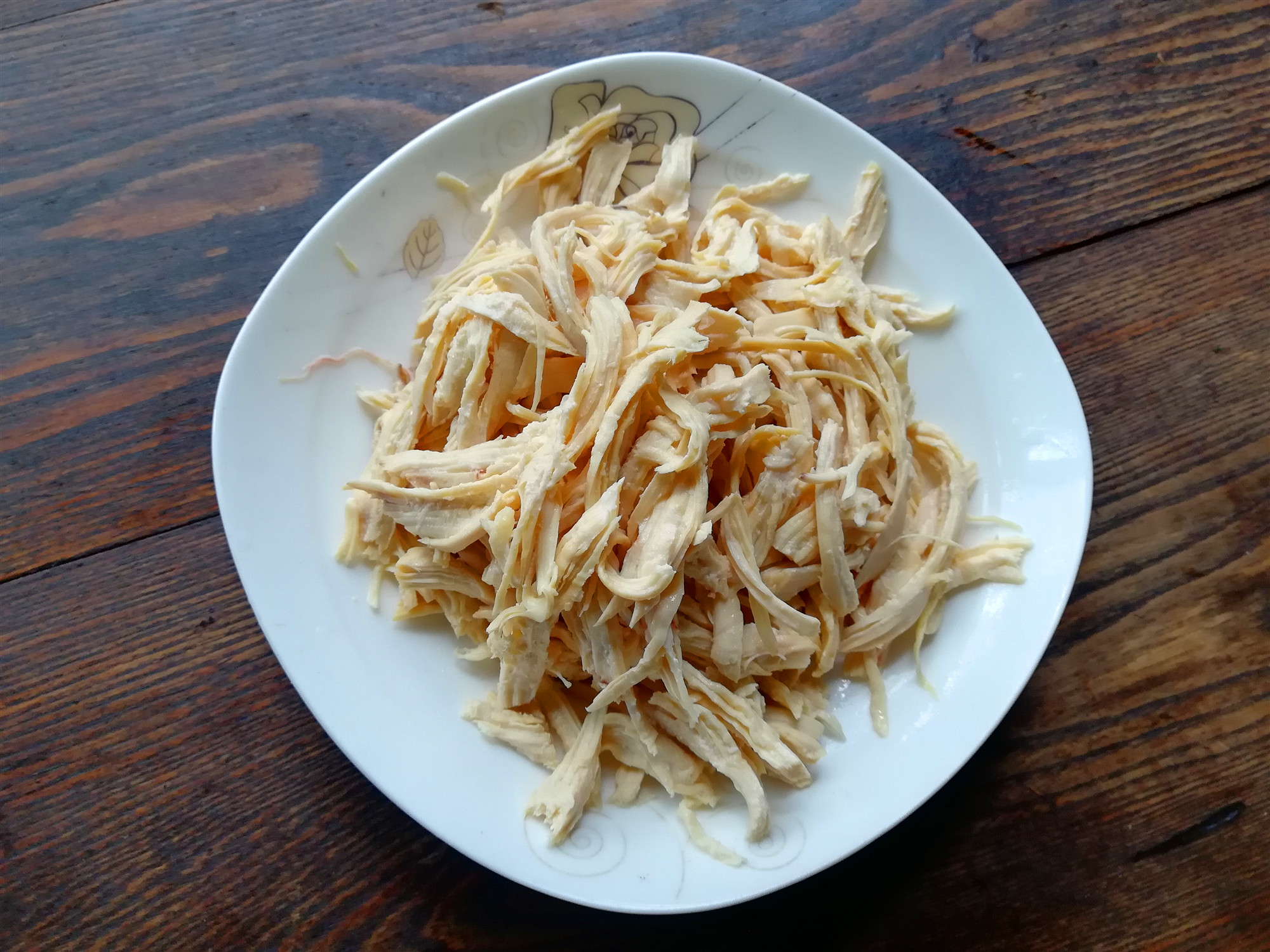 将鸡肉丝,黄瓜丝,洋葱丝,胡萝卜丝放在大一些的容器内,加入香菜段,蒜