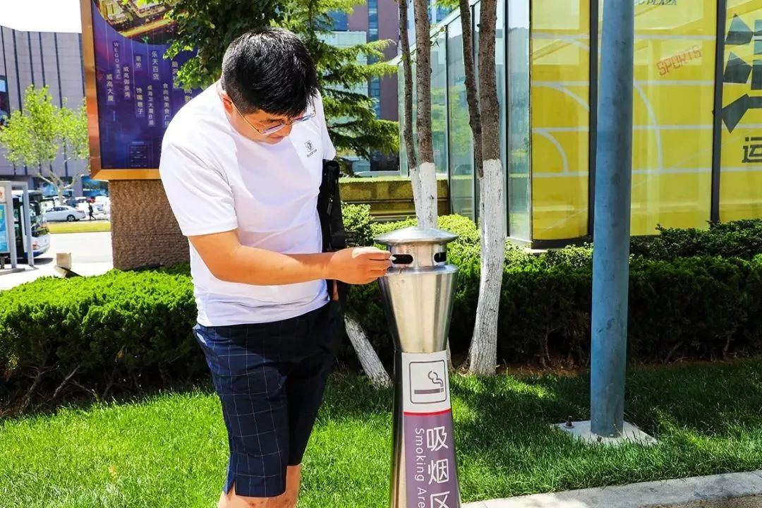 主动去灭烟处掐灭烟头的年轻人