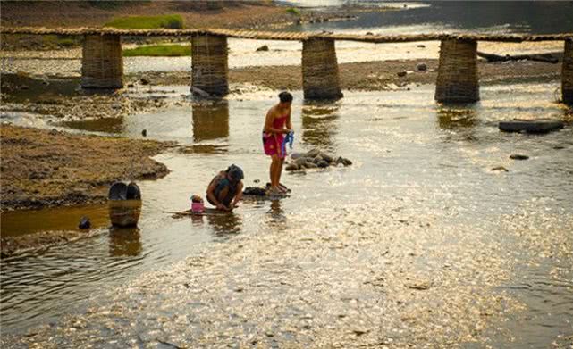 柬埔寨农村的惬意生活:女人在河里洗澡,男人在一旁吹牛说笑