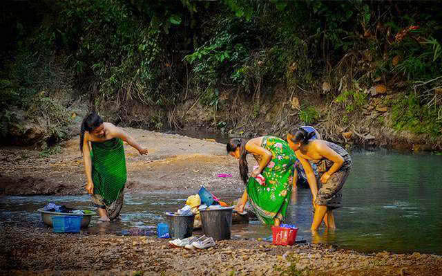 柬埔寨农村的惬意生活:女人在河里洗澡,男人在一旁吹牛说笑