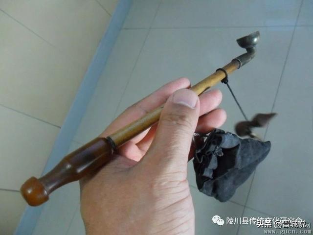 头顶白羊肚手巾,腰裹布腰带,别在腹腰的旱烟袋和吊着的烟丝袋