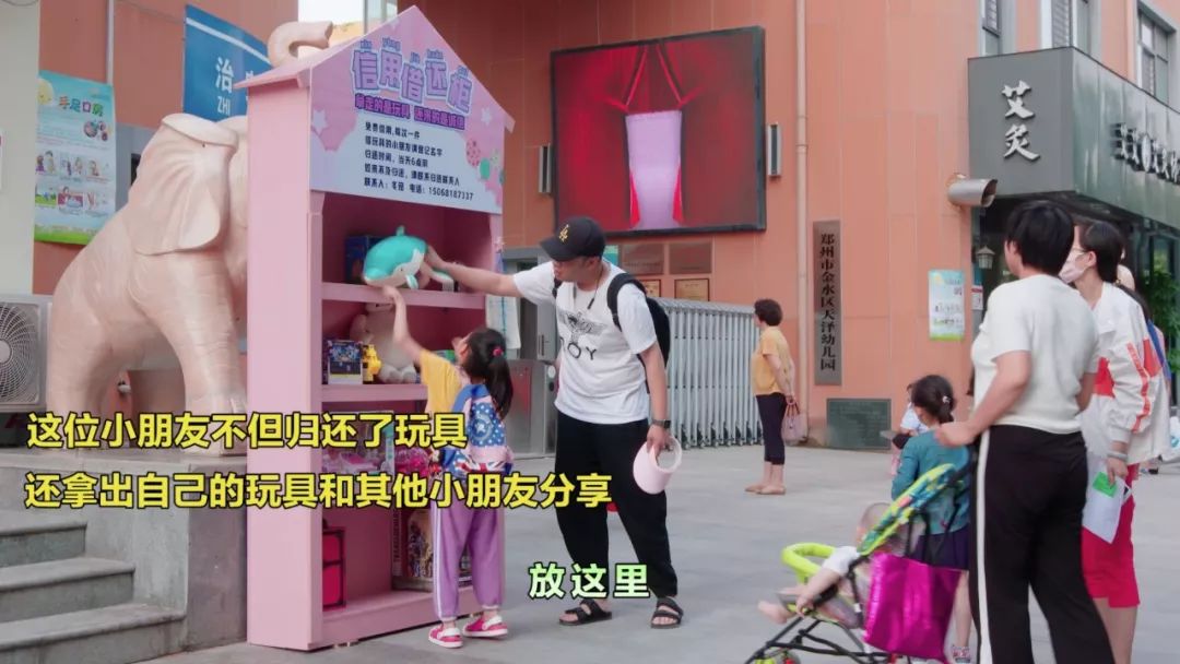 放学后看到玩具柜拉着妈妈的手吵闹着要玩妈妈指着柜子上的借还时间