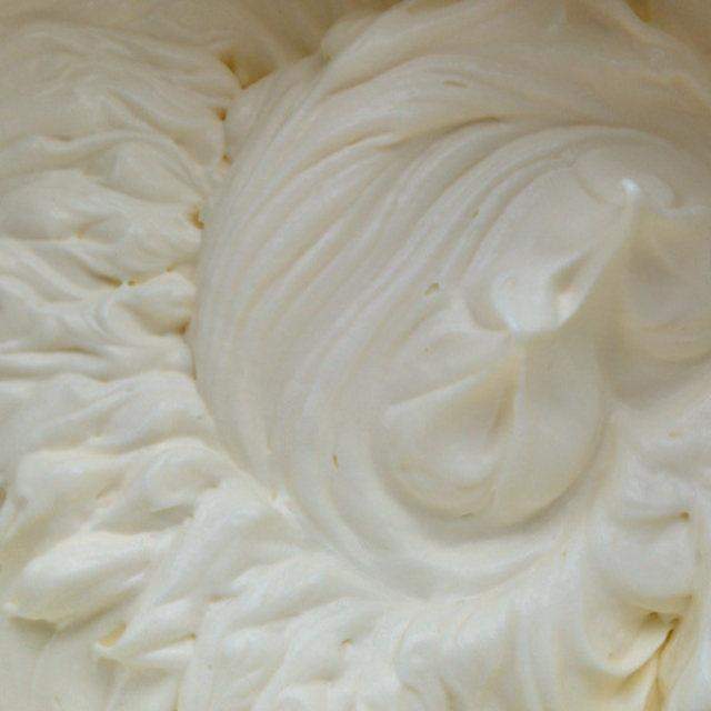 将一片烤好的酥皮面朝下放好,再抹少许奶油,然后小心卷起