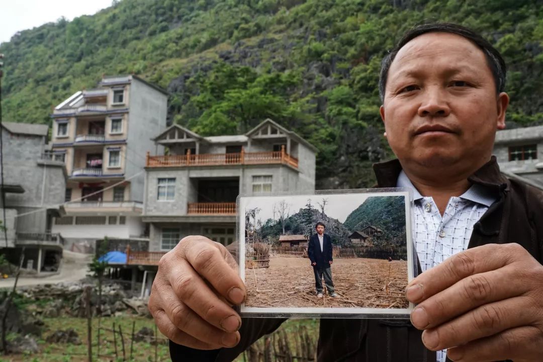 照片里是罗文进的茅草房,背后最高的建筑是他的新家"罗文新:"哪怕到我