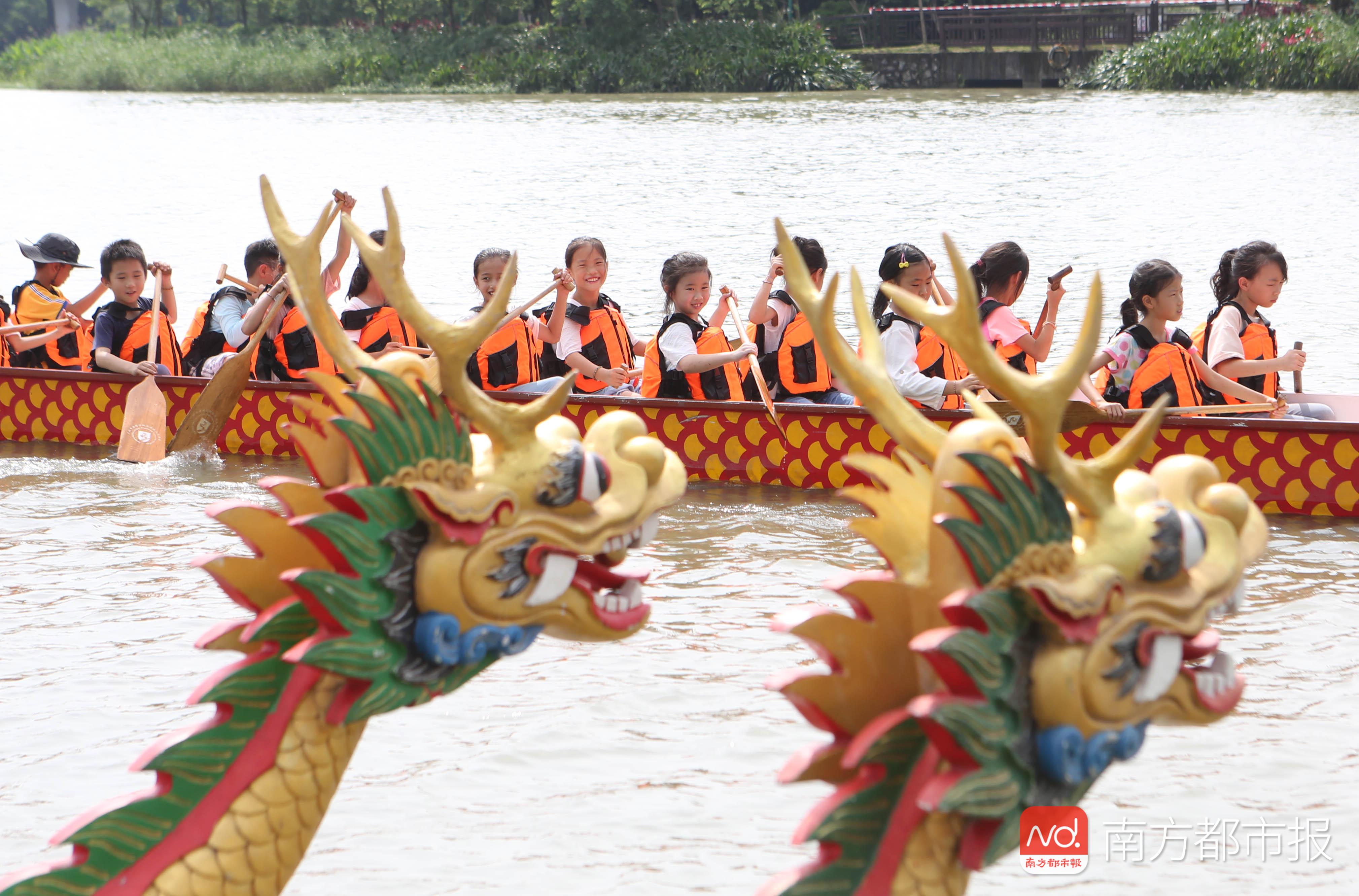 湿地龙船景"活动在广州海珠湿地公园举行,小学生在龙舟上体验划龙船