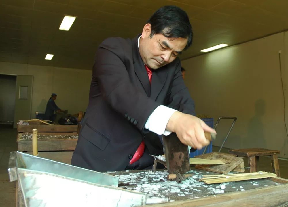 "樟帮"第七代炮制传人袁小平在铡药2014年,樟树中药炮制技艺被列入第