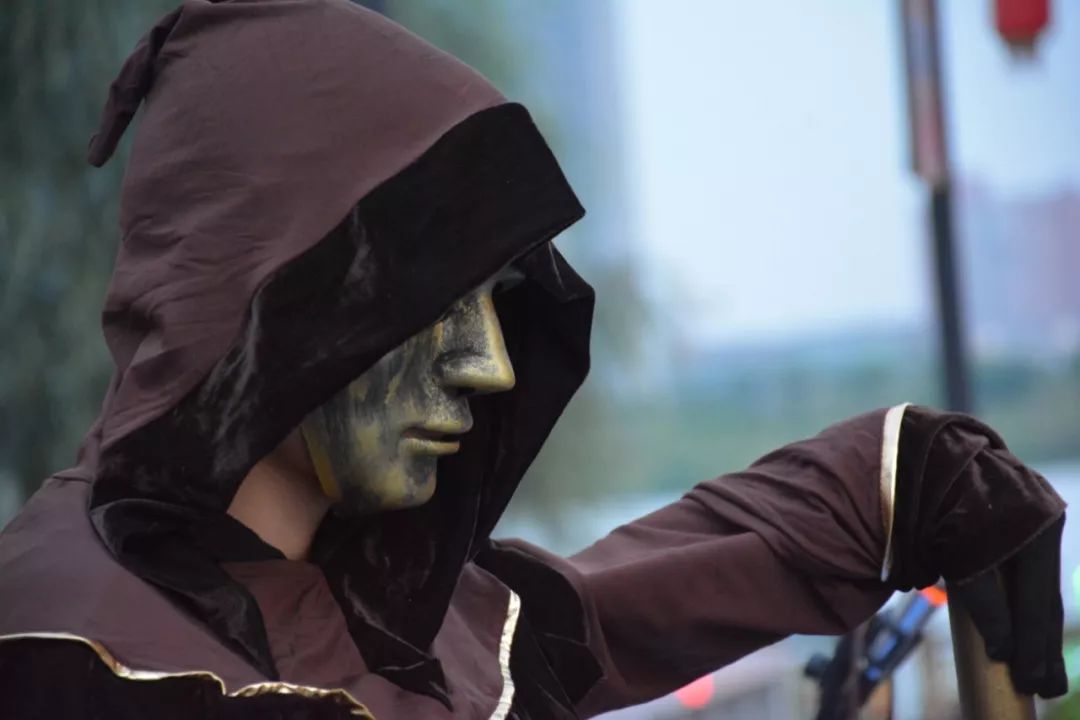 身穿咖啡色法袍悬浮于空中常德街头艺人周伟祥面戴青铜面具在常德河街