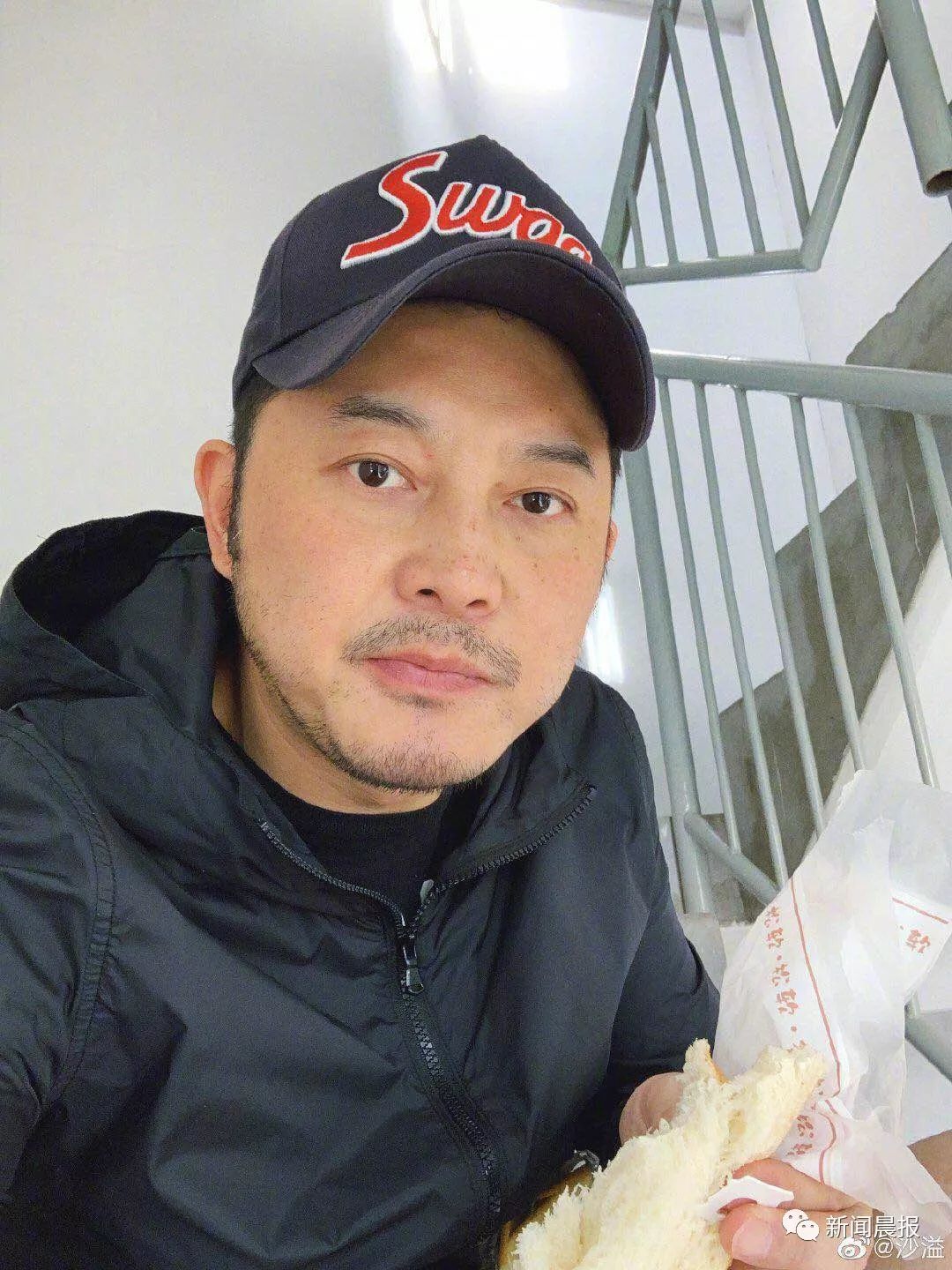 近日沙溢的一张陪孩子上补习班 他在安全通道坐着啃面包的消息 照片