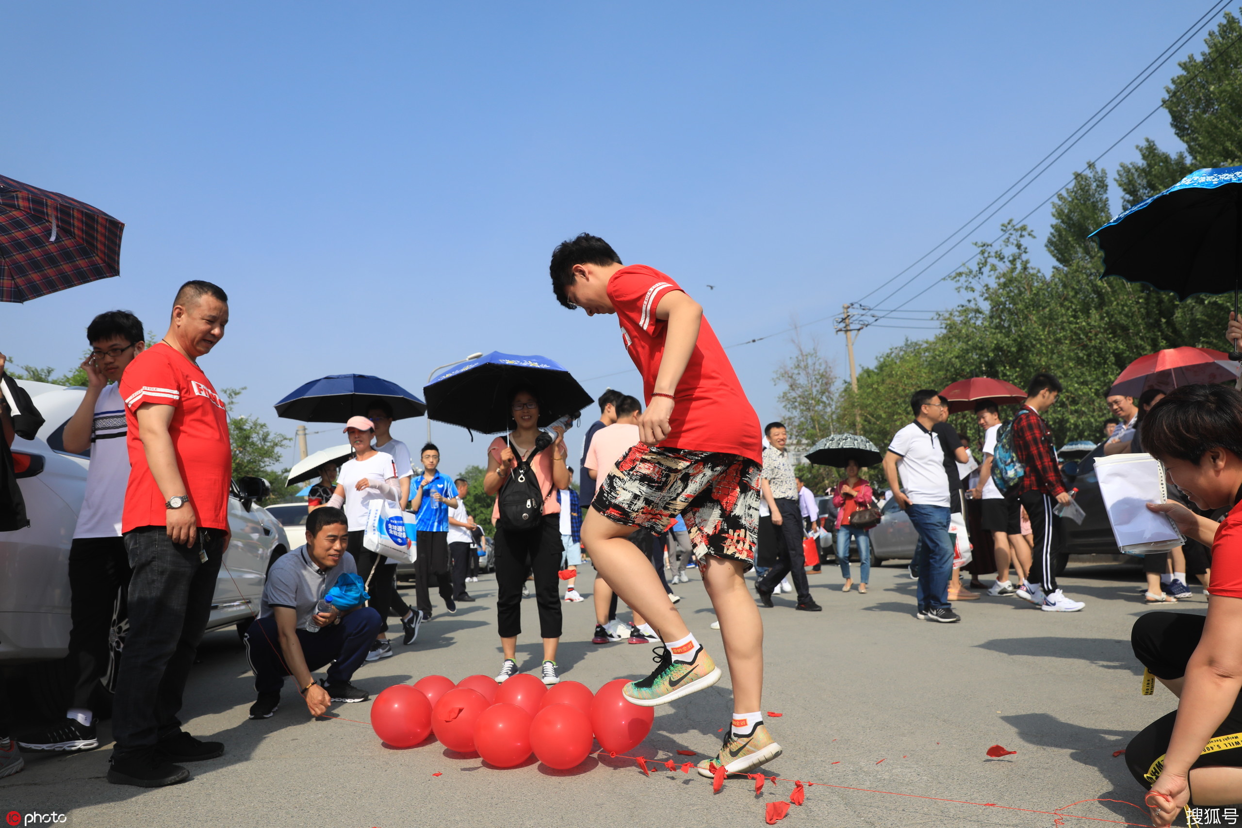 家长为孩子准备红色气球 进场前踩爆寓意必有彩报