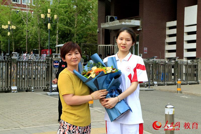 中国人民大学附属中学考点前,曹雨荷与妈妈合影留念 李依环/摄