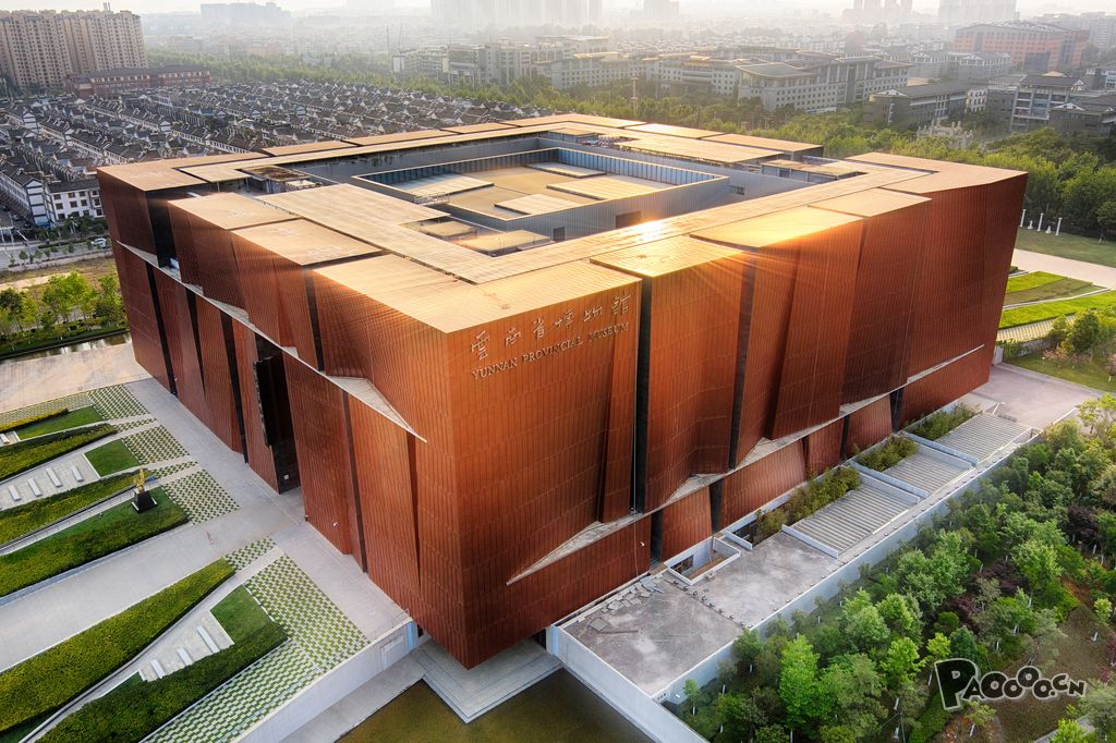 平面呈回字形,取意于云南彝族"一颗印"式传统民居建筑,外墙选用深铜色