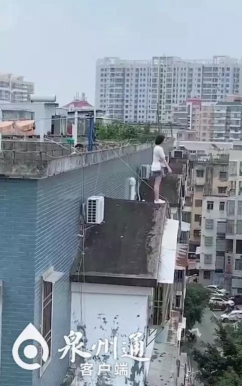 但双手并没有攀握边缘不时走动了几步这名年轻女子站在楼顶的窗台边缘