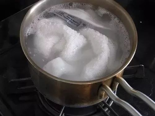 等水稍稍冷却一点再把毛巾放到煮好的柠檬水里,用手仔细搓一搓,拧干
