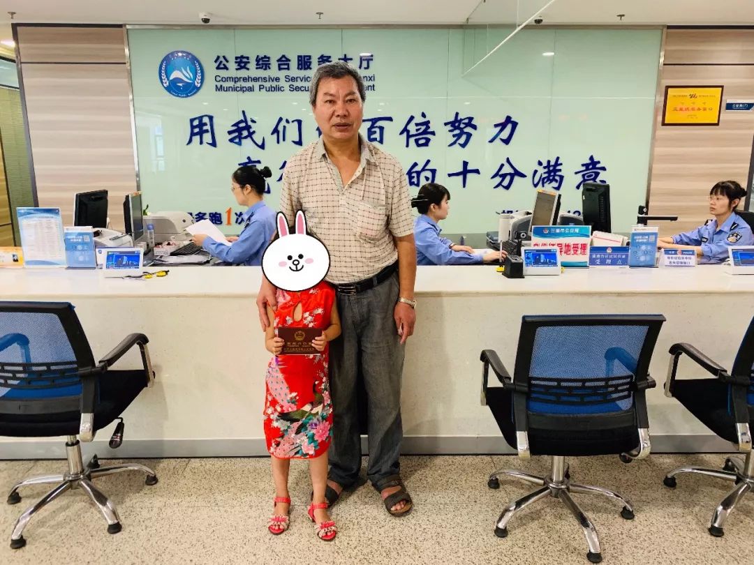 一位穿着旗袍的小女孩拿着户口本和爷爷开心地拍下了属于她的第一张"