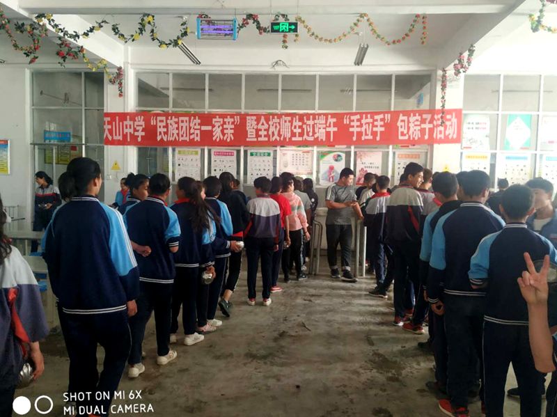 主题活动县天山中学举行"民族团结一家亲"暨全校师生过端午"手拉手"包