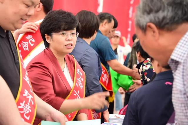 张武全,尧都区副区长汤晓燕和环保工作人员一起向群众发放宣传资料