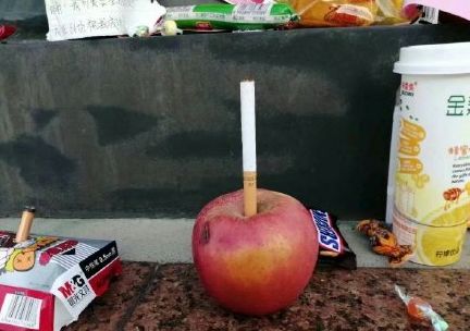 这些贡品中不乏小零食,水果,冷饮,书本,甚至还有香烟,仔细看还能发现