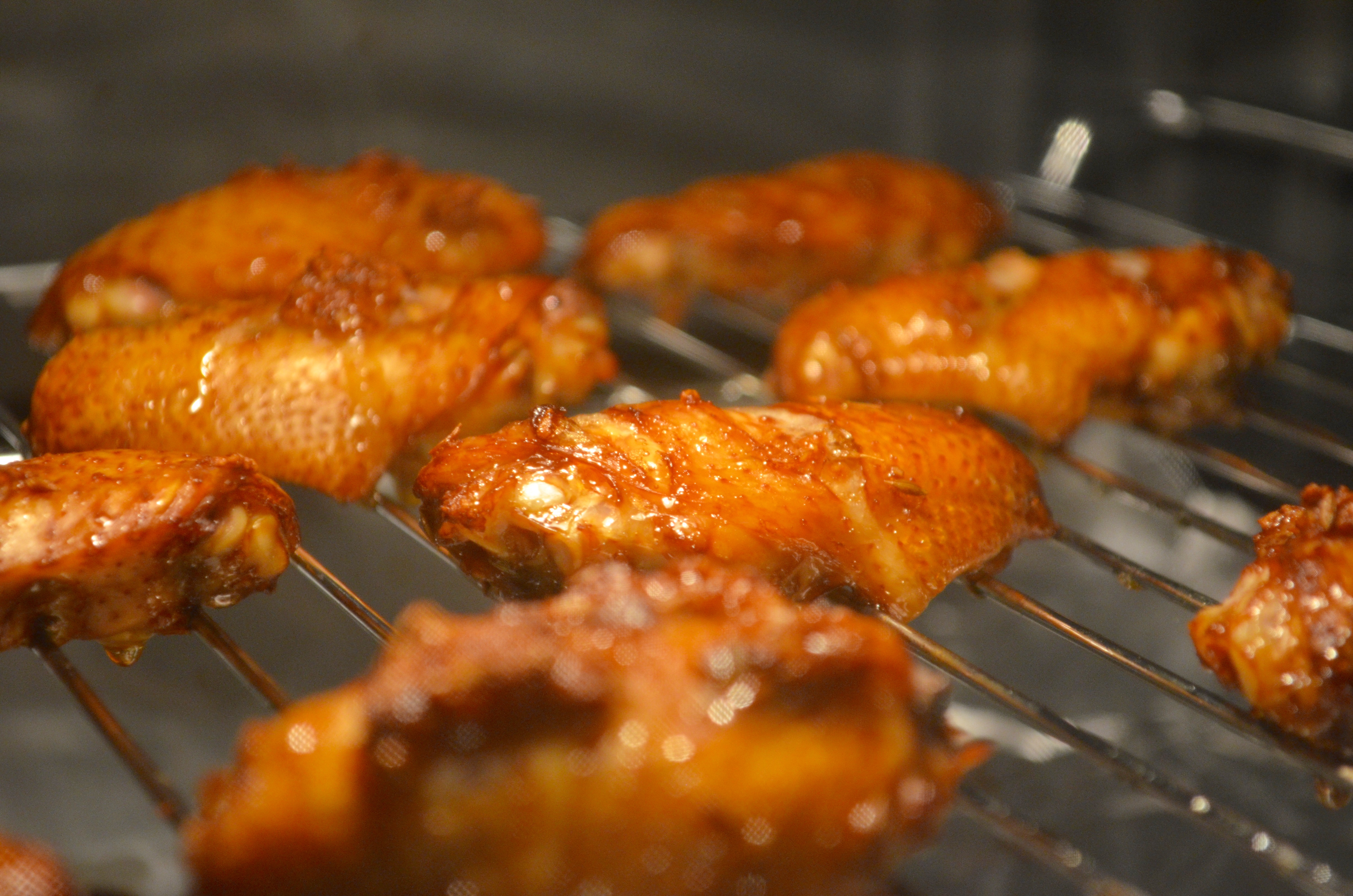 继续烤制,在烤制过程中将鸡翅背部划开两道,也可以在腌制步骤划开