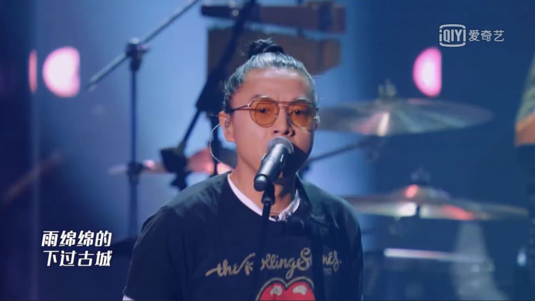 丸子头,略带银丝穿插其中;一副墨镜,一件黑色t恤,就这样上了台.